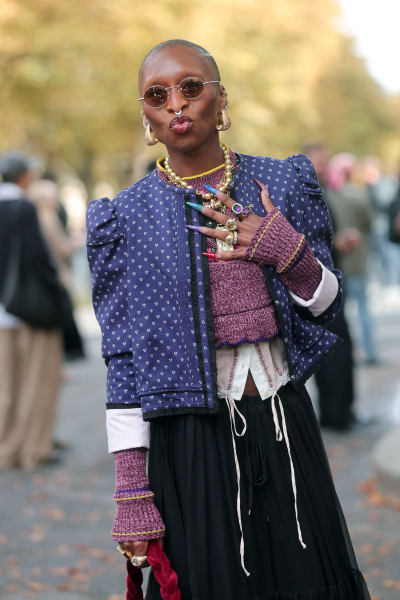 Cynthia Erivo poses at Fashion week in a blue jacket and multicolored French manicure.